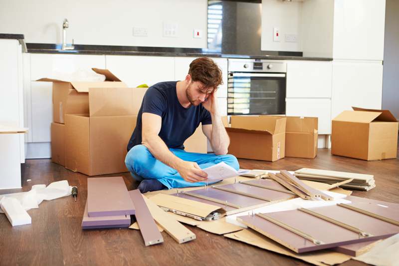 frustrated man building flat pack furniture
